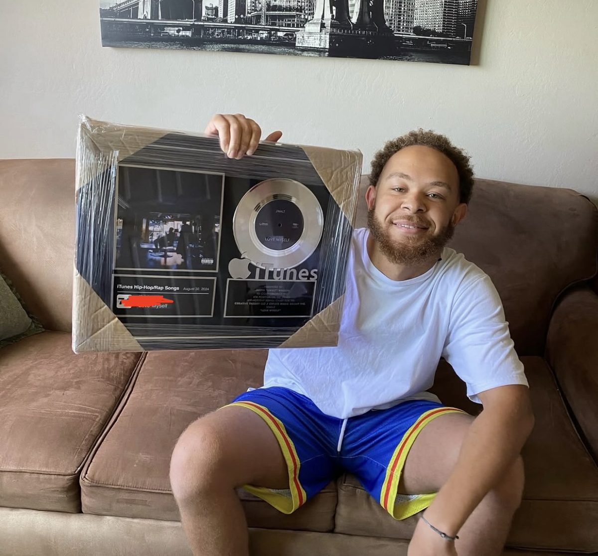 Jwalt holding his framed iTunes chart plaque for Love Myself